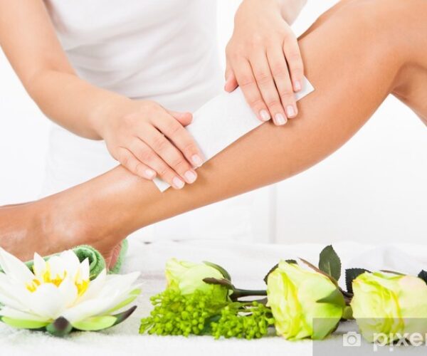 Beautician Waxing A Woman's Leg